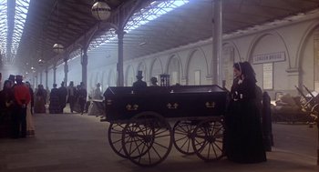 Movie still from “The Great Train Robbery” (1978), directed by Michael Crichton – People in period clothing stand around a black carriage; Wide shot, Low angle