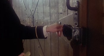 Movie still from “The Great Train Robbery” (1978), directed by Michael Crichton – A hand is pressing a button on a metal door; Close Up shot, High angle