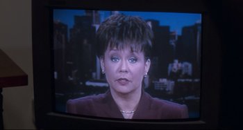 Movie still from “The First Wives Club” (1996), directed by Hugh Wilson – A television screen showing a woman in a purple suit; Close Up shot, High angle