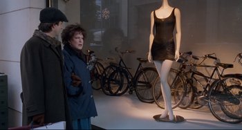 Movie still from “The First Wives Club” (1996), directed by Hugh Wilson – A woman standing in front of mannequins and bicycles; Wide shot, Over the shoulder angle