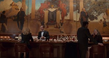 Movie still from “The First Wives Club” (1996), directed by Hugh Wilson – A man in a tuxedo sitting at a bar; Wide shot, Over the shoulder angle