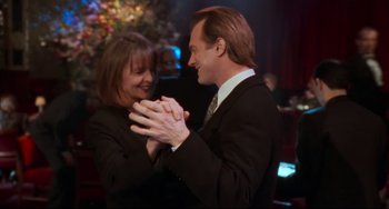 Movie still from “The First Wives Club” (1996), directed by Hugh Wilson – A man and a woman are dancing together in front of a christmas tree; Medium shot, Over the shoulder angle