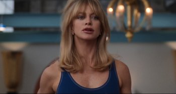 Movie still from “The First Wives Club” (1996), directed by Hugh Wilson – A woman with long blonde hair wearing a blue tank top; Close Up shot, Low angle