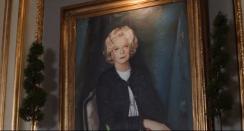 Movie still from “The First Wives Club” (1996), directed by Hugh Wilson – A painting of an older woman with blonde hair; Medium shot, Low angle