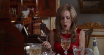 Movie still from “The First Wives Club” (1996), directed by Hugh Wilson – A woman sitting at a table with a fork in her hand; Medium shot, High angle