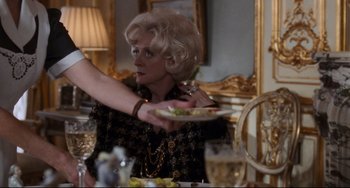 Movie still from “The First Wives Club” (1996), directed by Hugh Wilson – A woman is holding a plate in her hand; Medium shot, Over the shoulder angle