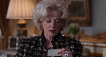 Movie still from “The First Wives Club” (1996), directed by Hugh Wilson – An older woman holding a business card in her hands; Close Up shot, Over the shoulder angle