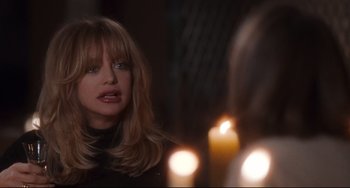 Movie still from “The First Wives Club” (1996), directed by Hugh Wilson – A woman looking at a candle in a room; Close Up shot, Over the shoulder angle