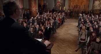 Movie still from “The First Wives Club” (1996), directed by Hugh Wilson – A large group of people sitting in a room; Wide shot, High angle