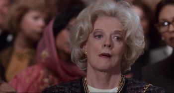 Movie still from “The First Wives Club” (1996), directed by Hugh Wilson – An older woman with blonde curly hair and wearing gold jewelry; Close Up shot, Over the shoulder angle