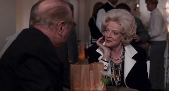 Movie still from “The First Wives Club” (1996), directed by Hugh Wilson – An older man and a woman sitting at a table; Medium shot, Over the shoulder angle