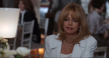 Movie still from “The First Wives Club” (1996), directed by Hugh Wilson – A woman in a white jacket and a pearl necklace; Close Up shot, Over the shoulder angle