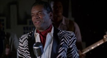 Movie still from “The Five Heartbeats” (1991), directed by Robert Townsend – A man in a zebra print jacket holding a microphone; Close Up shot, Over the shoulder angle