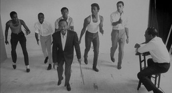 Movie still from “The Five Heartbeats” (1991), directed by Robert Townsend – A black and white photo of a group of men running; Medium shot, High angle