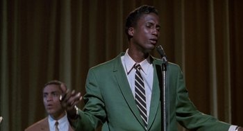 Movie still from “The Five Heartbeats” (1991), directed by Robert Townsend – A man wearing a green suit and a striped neck tie; Close Up shot, Low angle