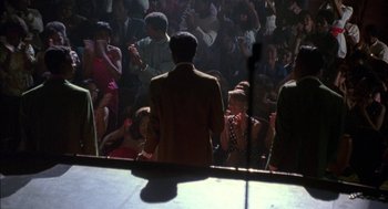 Movie still from “The Five Heartbeats” (1991), directed by Robert Townsend – A crowd of people sitting in front of a stage; Wide shot, High angle