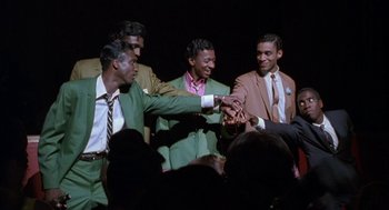 Movie still from “The Five Heartbeats” (1991), directed by Robert Townsend – A group of men in suits and ties holding hands; Medium shot, High angle