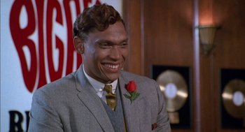 Movie still from “The Five Heartbeats” (1991), directed by Robert Townsend – A man wearing a suit and tie with a flower in his lapel; Close Up shot, Low angle
