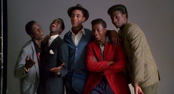 Movie still from “The Five Heartbeats” (1991), directed by Robert Townsend – A group of men standing next to each other in suits; Medium shot, Low angle