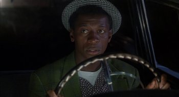 Movie still from “The Five Heartbeats” (1991), directed by Robert Townsend – A man in a hat is sitting in a car; Close Up shot, Over the shoulder angle