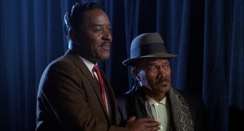 Movie still from “The Five Heartbeats” (1991), directed by Robert Townsend – A couple of men standing next to each other; Medium shot, Low angle
