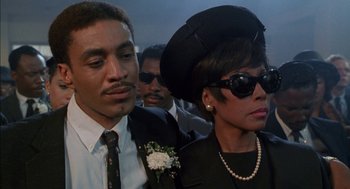 Movie still from “The Five Heartbeats” (1991), directed by Robert Townsend – A man and a woman in a black suit and hat; Close Up shot, Low angle
