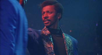 Movie still from “The Five Heartbeats” (1991), directed by Robert Townsend – A man in a blue jacket and a black shirt; Close Up shot, Low angle