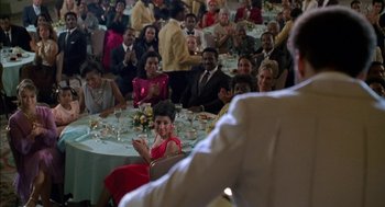 Movie still from “The Five Heartbeats” (1991), directed by Robert Townsend – A group of people sitting at a table with food; Medium shot, Over the shoulder angle