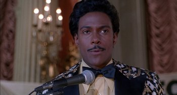 Movie still from “The Five Heartbeats” (1991), directed by Robert Townsend – A man with a microphone in front of a microphone stand; Close Up shot, High angle