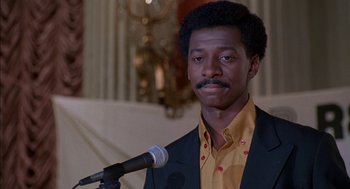 Movie still from “The Five Heartbeats” (1991), directed by Robert Townsend – A man in a yellow shirt is holding a microphone; Close Up shot, Low angle