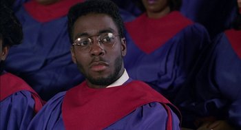 Movie still from “The Five Heartbeats” (1991), directed by Robert Townsend – A man in a purple and red graduation gown; Close Up shot, Low angle