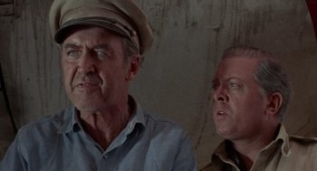 Movie still from “The Flight of the Phoenix” (1965), directed by Robert Aldrich – A man and a man wearing a hat; Close Up shot, Low angle