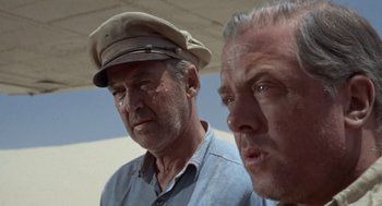 Movie still from “The Flight of the Phoenix” (1965), directed by Robert Aldrich – Two men wearing hats looking at the camera; Close Up shot, Low angle