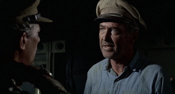 Movie still from “The Flight of the Phoenix” (1965), directed by Robert Aldrich – An older man wearing a hat talking to a younger man; Close Up shot, Over the shoulder angle