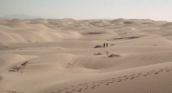 Movie still from “The Flight of the Phoenix” (1965), directed by Robert Aldrich – A couple of people are walking in the desert; Extreme Wide shot, High angle