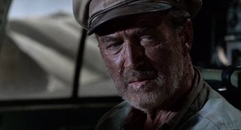 Movie still from “The Flight of the Phoenix” (1965), directed by Robert Aldrich – An older man wearing a hat and looking at the camera; Close Up shot, Low angle