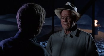 Movie still from “The Flight of the Phoenix” (1965), directed by Robert Aldrich – An older man wearing glasses and a hat talking to a younger man; Close Up shot, Over the shoulder angle