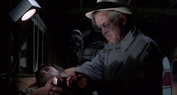 Movie still from “The Flight of the Phoenix” (1965), directed by Robert Aldrich – An older man is shaving his face with a razor; Close Up shot, Low angle
