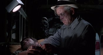 Movie still from “The Flight of the Phoenix” (1965), directed by Robert Aldrich – An older man is shaving his face with a razor; Close Up shot, Low angle