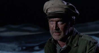Movie still from “The Flight of the Phoenix” (1965), directed by Robert Aldrich – An older man wearing a hat and a jacket; Close Up shot, Over the shoulder angle