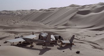 Movie still from “The Flight of the Phoenix” (1965), directed by Robert Aldrich – An airplane sitting in the middle of the desert; Extreme Wide shot, High angle