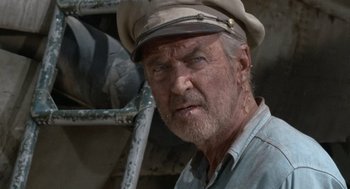 Movie still from “The Flight of the Phoenix” (1965), directed by Robert Aldrich – An older man wearing a hat and looking at the camera; Close Up shot, Low angle