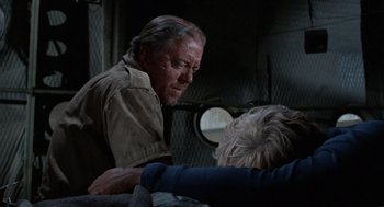 Movie still from “The Flight of the Phoenix” (1965), directed by Robert Aldrich – An older man and a younger woman in an industrial setting; Close Up shot, Over the shoulder angle