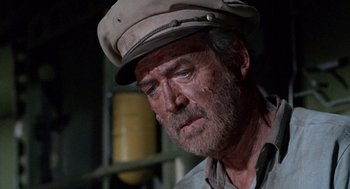 Movie still from “The Flight of the Phoenix” (1965), directed by Robert Aldrich – An older man wearing a hat looking down at the ground; Close Up shot, Low angle