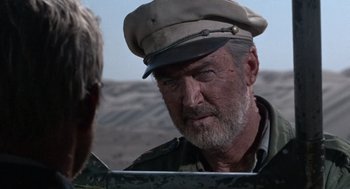 Movie still from “The Flight of the Phoenix” (1965), directed by Robert Aldrich – An older man wearing a hat looking into a mirror; Close Up shot, Over the shoulder angle