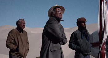 Movie still from “The Flight of the Phoenix” (1965), directed by Robert Aldrich – A group of men standing next to each other in the desert; Medium shot, Low angle