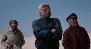 Movie still from “The Flight of the Phoenix” (1965), directed by Robert Aldrich – A group of people standing next to each other in the desert; Medium shot, Low angle