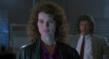 Movie still from “The Fly” (1986), directed by David Cronenberg – A woman with curly red hair wearing a leather jacket; Close Up shot, Over the shoulder angle