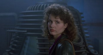 Movie still from “The Fly” (1986), directed by David Cronenberg – A person with curly hair wearing a leather jacket; Close Up shot, Low angle