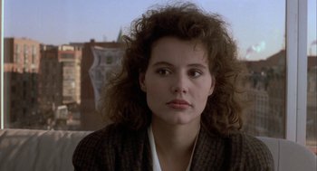 Movie still from “The Fly” (1986), directed by David Cronenberg – A person with curly hair wearing a suit; Close Up shot, Over the shoulder angle